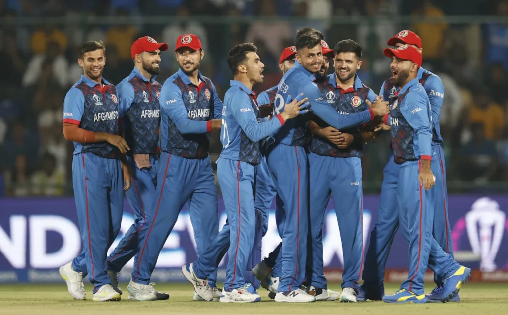 Smiling Afghan Cricket Team celebrates a wicket with Mujeeb