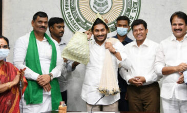 CM Jagan wearing a fishermen hat with leaders in governement office.