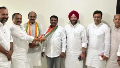 Teenmar Mallanna being welcomed into Congress party with a party scarf in front of party leaders.