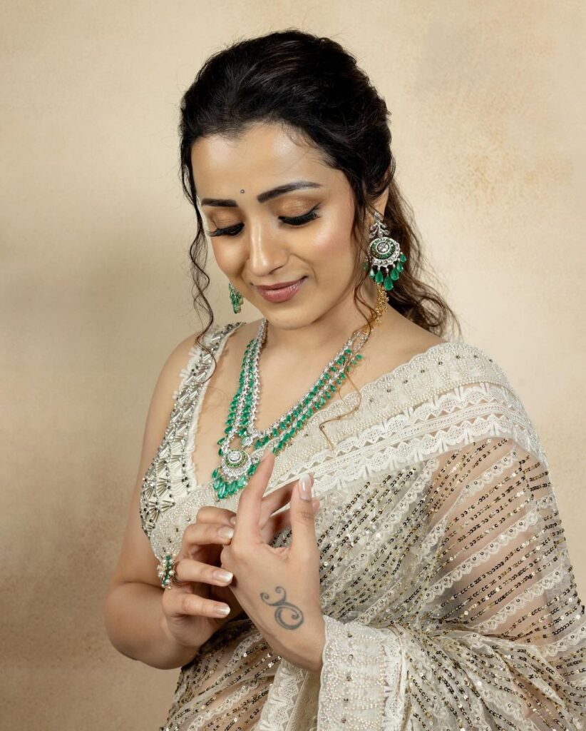 Trisha looks graceful in her white and green saree