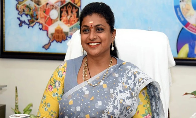 Minister Roja smiling in her office chair.