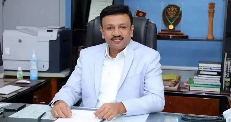 N Sridhar IAS in light blue suit in office.