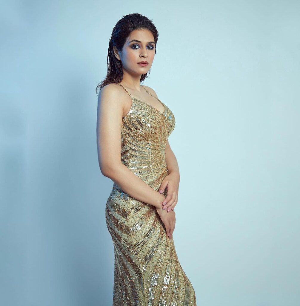 Shraddha Das stuns in a gold outfit, accentuated by a large pearl ring and earrings