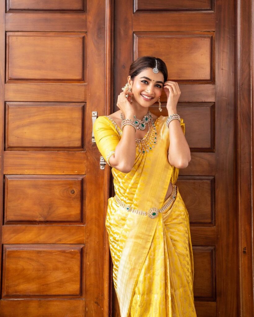 Pooja Hegde's yellow saree, green beads, and choukar create a stunning traditional aesthetic
