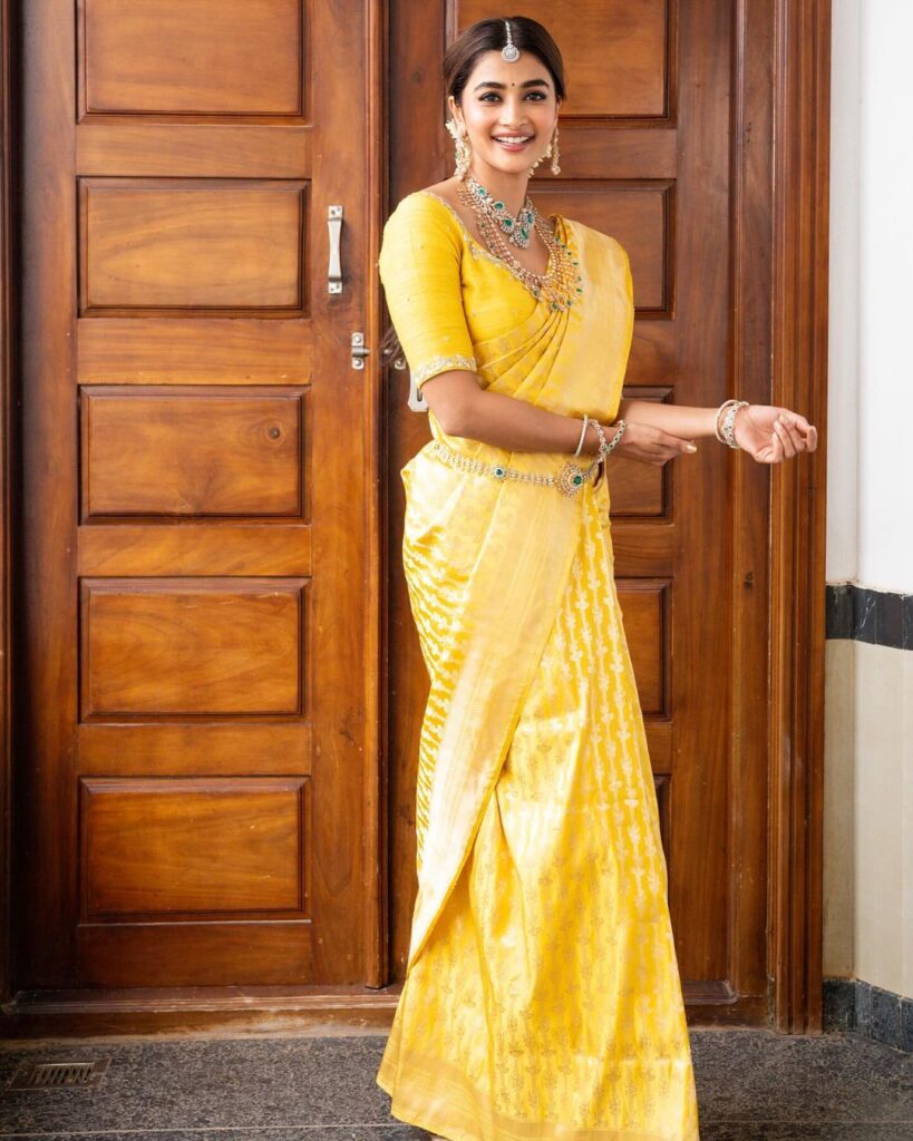 Pooja Hegde dons a yellow pattu saree with green beads