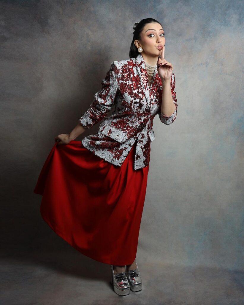 Hansika's red and grey ensemble with silver heels and a chic ponytail