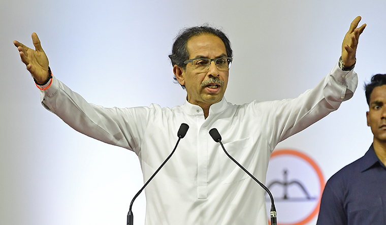 Uddhav Thackeray with arms high in speech.