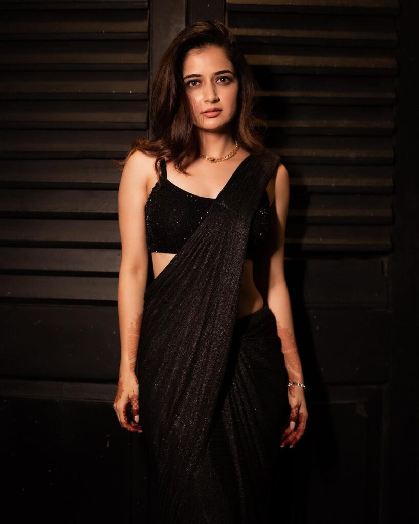 Ashika's captivating allure in a daring black saree