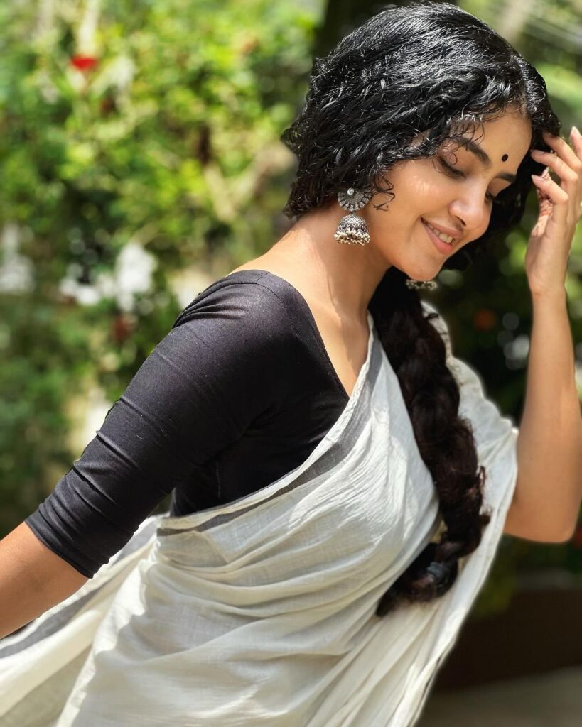 Elegant Anupama in white saree and black blouse.